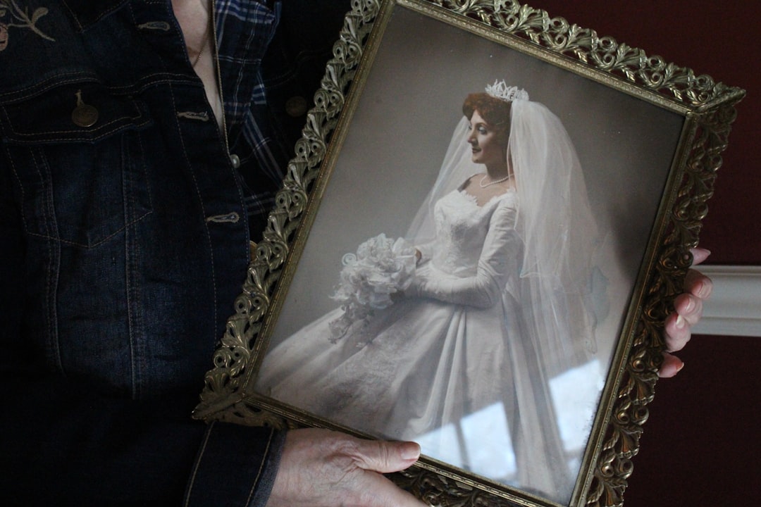 A woman holding a framed picture of a bride