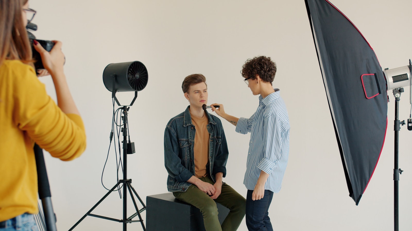 Makeup artist applies makeup to model in studio