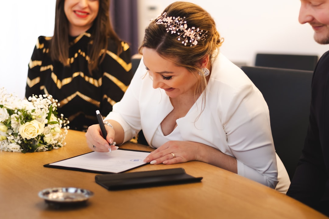 Bride signs the marriage certificate with a smile.