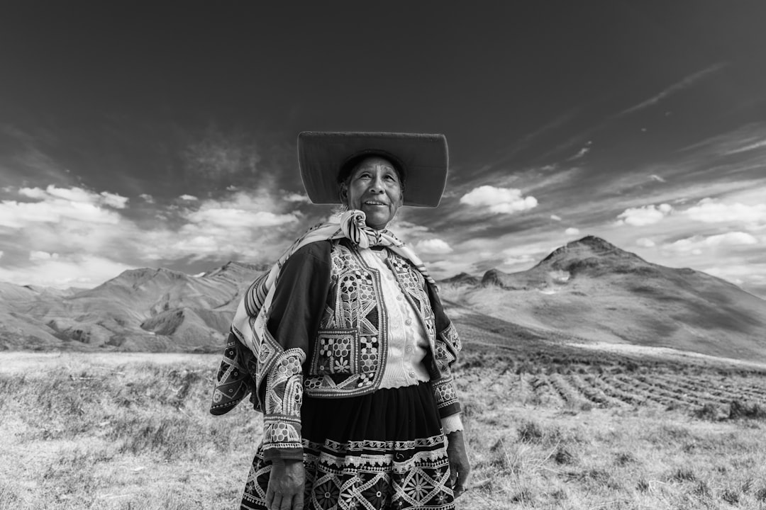 Elderly woman in traditional clothing with mountains behind