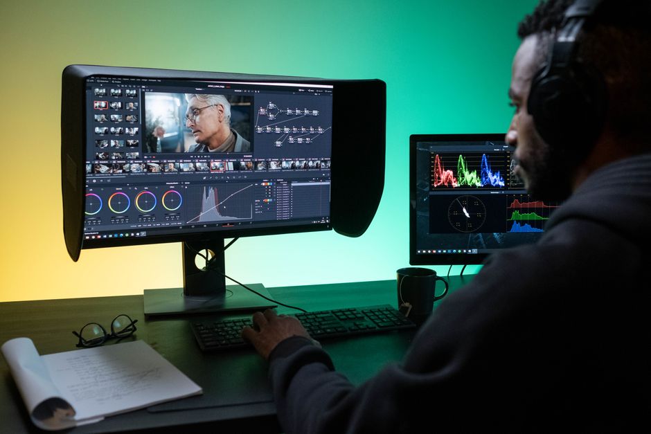 Photographer color grading a portrait on a dual-monitor editing setup
