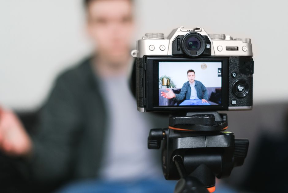 Photographer filming video content with a mirrorless camera on a tripod